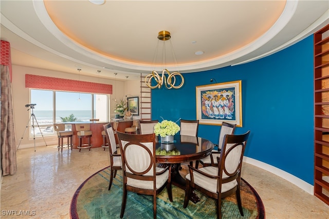 dining area with a chandelier and a tray ceiling