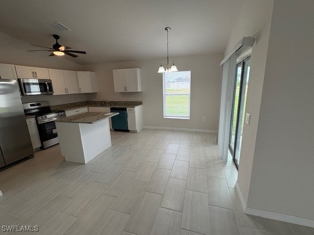 kitchen with ceiling fan with notable chandelier, stainless steel appliances, a center island, white cabinetry, and hanging light fixtures