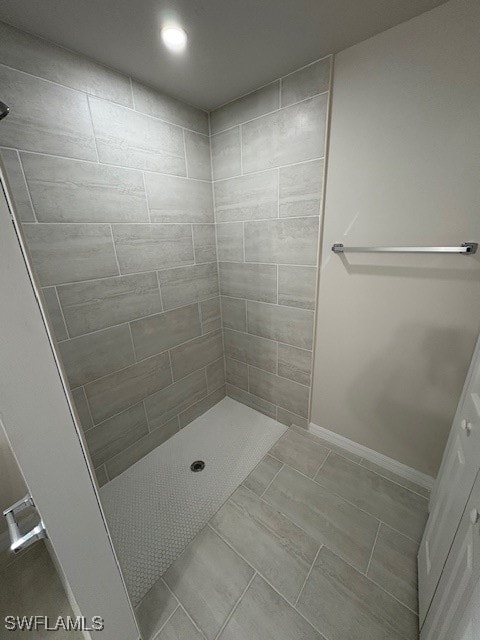 bathroom with tile patterned floors and tiled shower