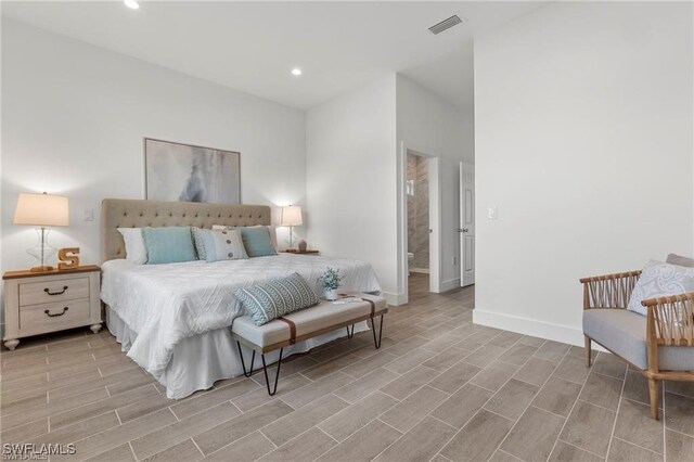 bedroom with light wood-type flooring and connected bathroom