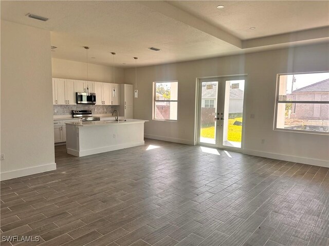 kitchen with white cabinets, appliances with stainless steel finishes, dark hardwood / wood-style floors, and hanging light fixtures