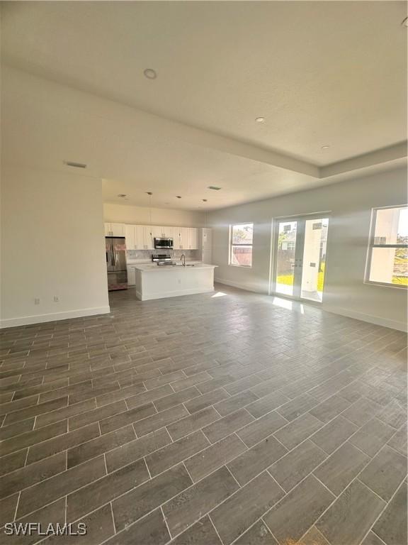 unfurnished living room with dark wood-type flooring