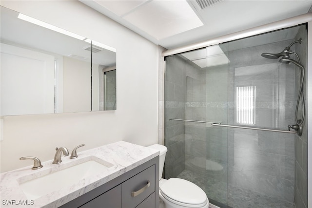 bathroom featuring visible vents, toilet, vanity, and a shower stall