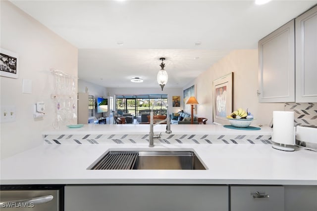 kitchen featuring dishwasher, tasteful backsplash, gray cabinetry, and sink