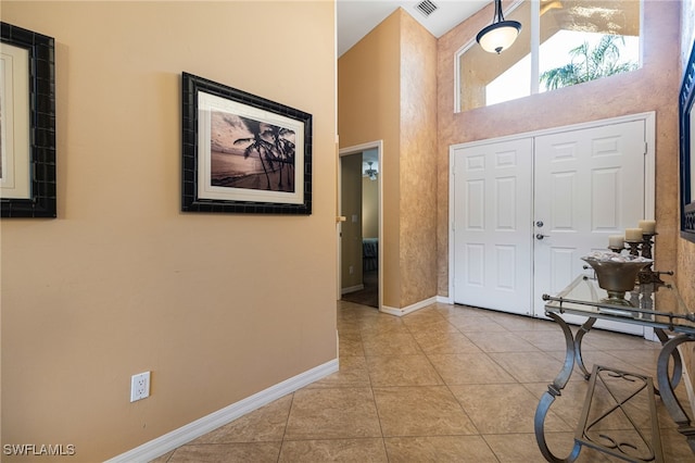 tiled entrance foyer featuring a high ceiling