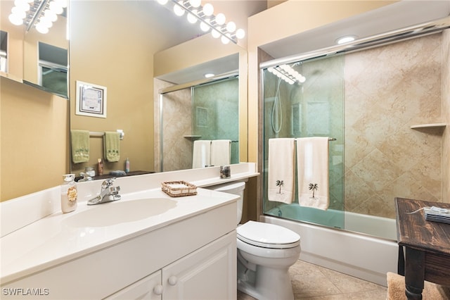 full bathroom featuring tile patterned flooring, vanity, bath / shower combo with glass door, and toilet