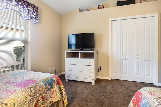 bedroom featuring a closet, dark carpet, and lofted ceiling