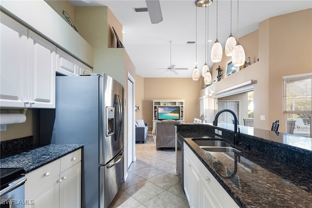 kitchen featuring stainless steel appliances, sink, pendant lighting, dark stone countertops, and white cabinetry