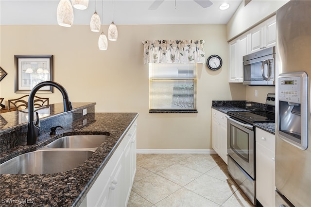 kitchen with dark stone counters, sink, hanging light fixtures, white cabinetry, and stainless steel appliances