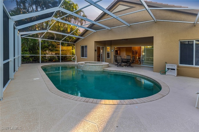 view of swimming pool with glass enclosure, an in ground hot tub, and a patio