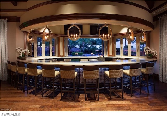 bar with hardwood / wood-style floors, hanging light fixtures, and a chandelier