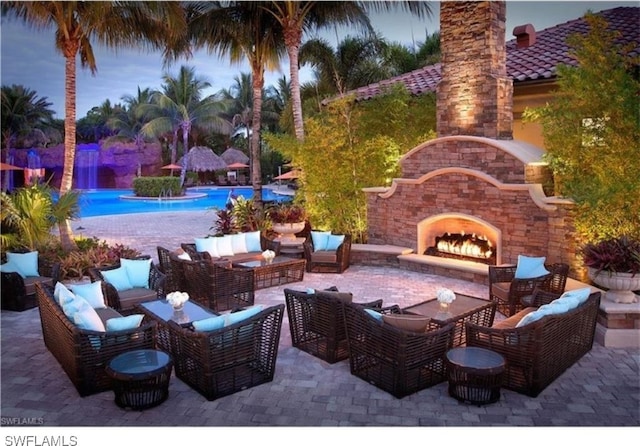 patio terrace at dusk with an outdoor living space with a fireplace