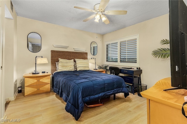 bedroom with ceiling fan, a textured ceiling, and light hardwood / wood-style flooring