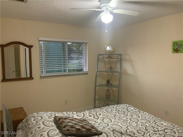 bedroom featuring ceiling fan and a textured ceiling