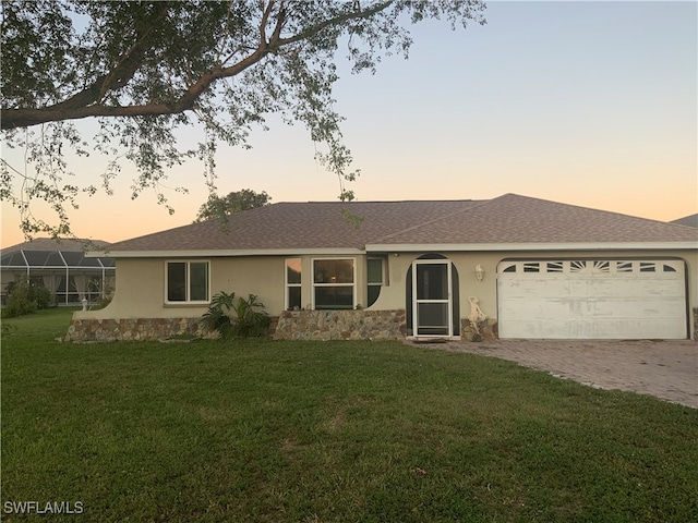 ranch-style home with a garage and a yard