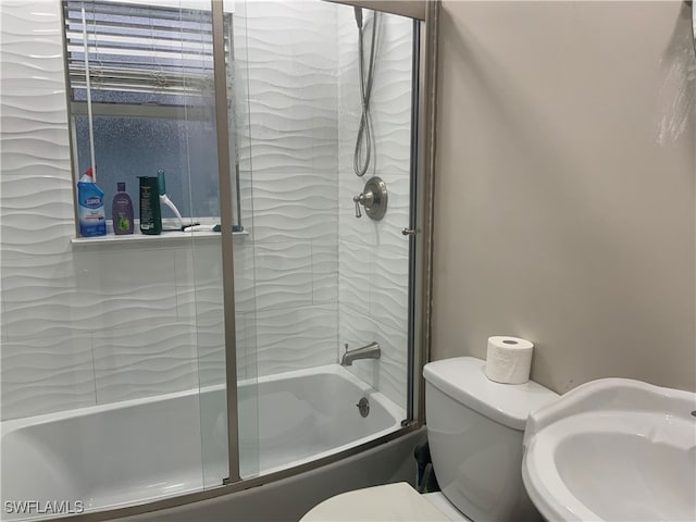 full bathroom featuring toilet, bath / shower combo with glass door, and sink