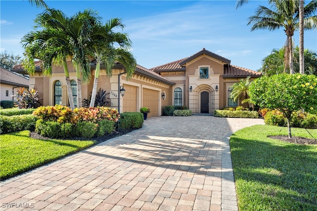 mediterranean / spanish-style home with a front yard and a garage