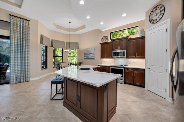 7399 Acorn Way, Naples, FL 34119 - kitchen featuring stainless steel appliances, light countertops, a kitchen island with sink, light tile patterned floors, and recessed lighting