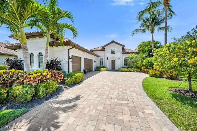 7399 Acorn Way, Naples, FL 34119 - mediterranean / spanish house with an attached garage, decorative driveway, stucco siding, and a tile roof