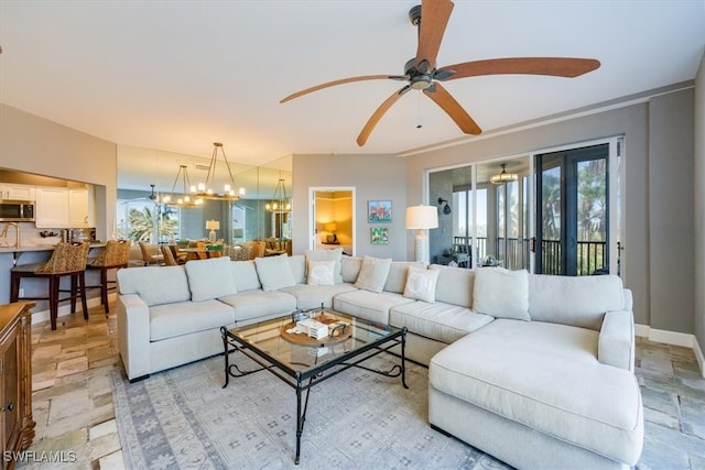 living room featuring ceiling fan with notable chandelier and a wealth of natural light