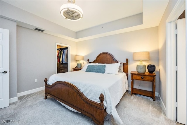 bedroom with a spacious closet, light carpet, and a closet