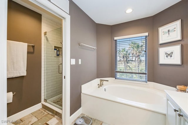 bathroom featuring vanity and independent shower and bath