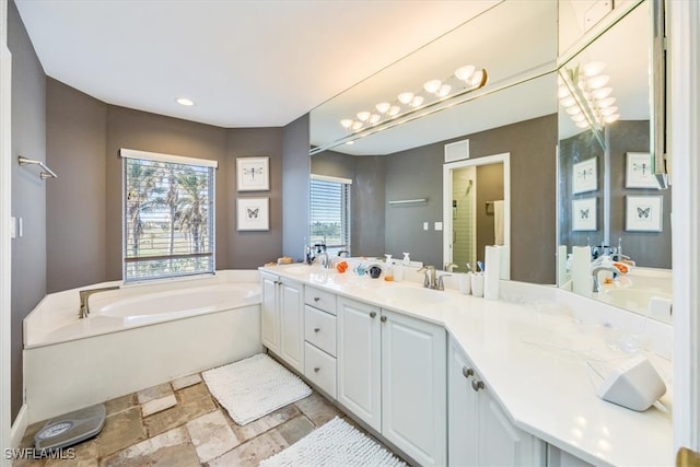 bathroom with a tub and vanity