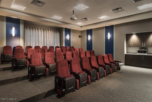 cinema with carpet flooring and a paneled ceiling