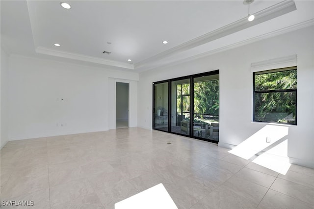 unfurnished room with a raised ceiling and ornamental molding