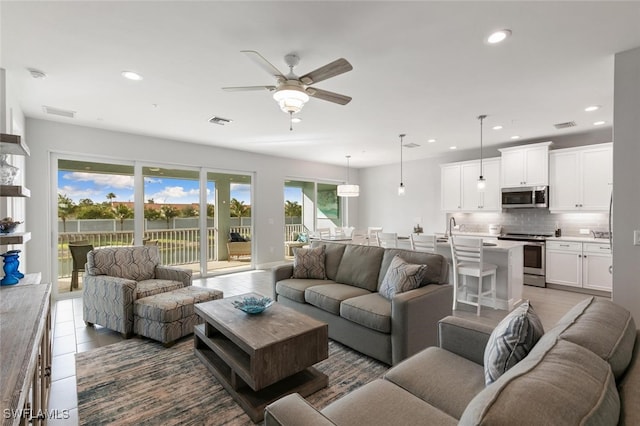 living room with tile patterned flooring and ceiling fan