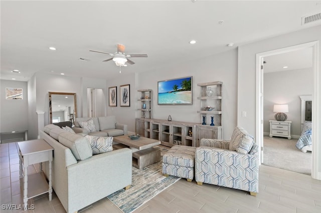 living room featuring ceiling fan and light colored carpet