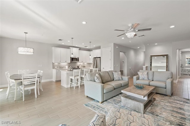 living room with light hardwood / wood-style flooring and ceiling fan