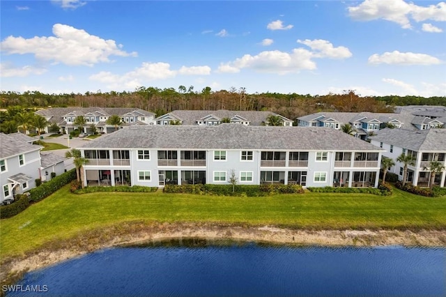 rear view of property featuring a yard and a water view