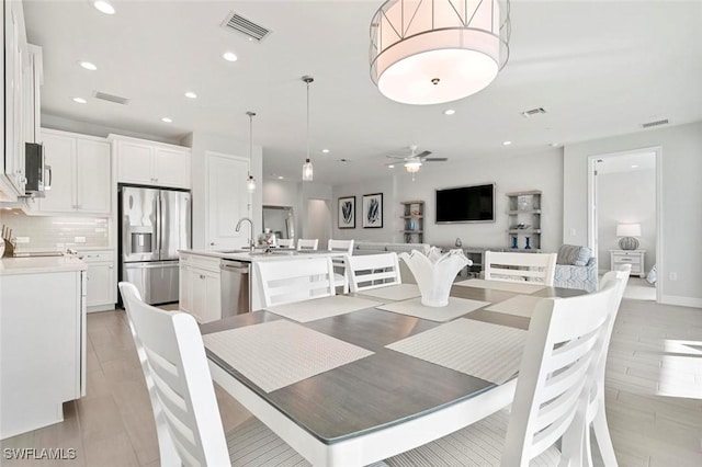 dining space featuring ceiling fan and sink