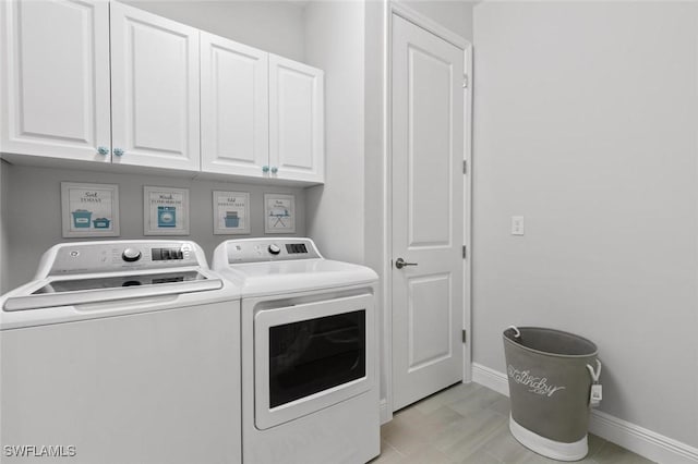 washroom with cabinets and washer and clothes dryer