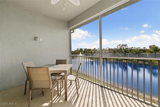 balcony with ceiling fan and a water view