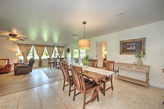 dining space featuring ceiling fan, a textured ceiling, and light wood-type flooring