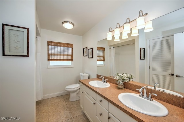 bathroom with toilet, vanity, and tile patterned floors