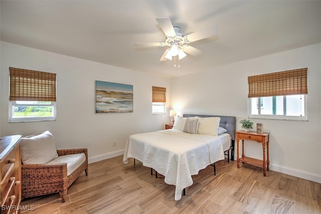 bedroom with multiple windows, ceiling fan, and light wood-type flooring