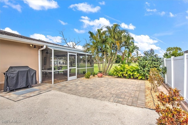 view of patio with area for grilling and a sunroom