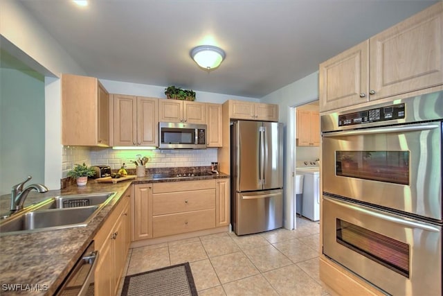 1656 Saint Clair Ave E, North Fort Myers, FL 33903 - kitchen with stainless steel appliances, light brown cabinetry, a sink, dark countertops, and backsplash