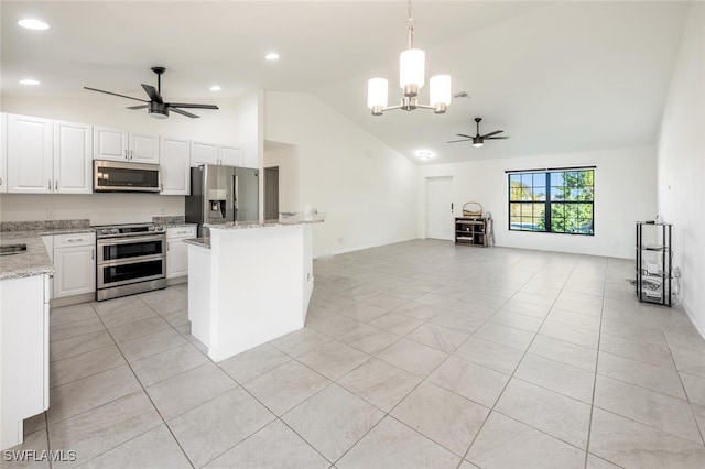 kitchen featuring white cabinetry, stainless steel appliances, light stone counters, pendant lighting, and lofted ceiling