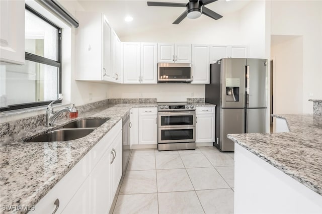 kitchen featuring white cabinets, stainless steel appliances, light stone countertops, and sink