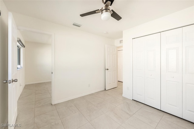 unfurnished bedroom with ceiling fan, a closet, and light tile patterned floors