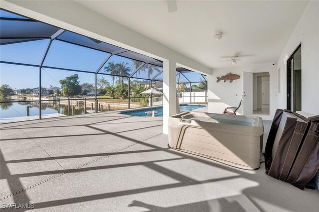 view of swimming pool with a lanai, a water view, ceiling fan, and a patio area