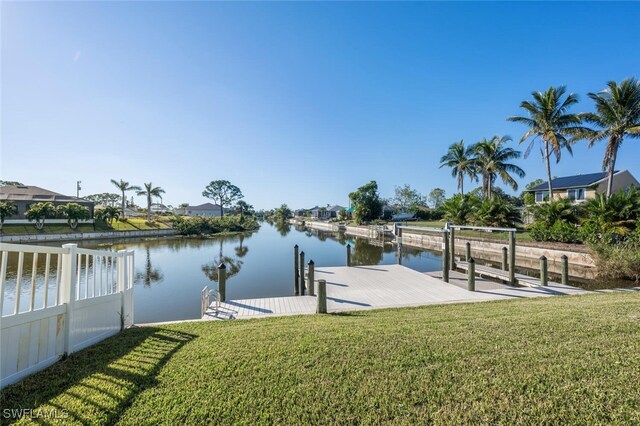 dock area with a water view and a lawn