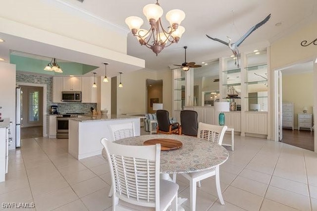 dining room featuring ceiling fan with notable chandelier, light tile patterned floors, and ornamental molding