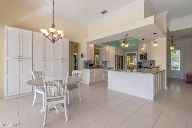 kitchen featuring decorative backsplash, white cabinetry, kitchen peninsula, and appliances with stainless steel finishes