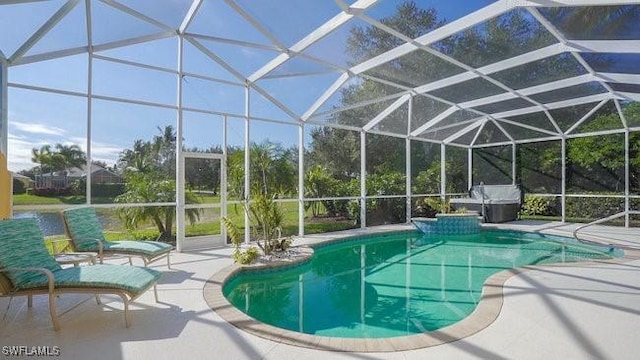 view of pool featuring glass enclosure and a patio