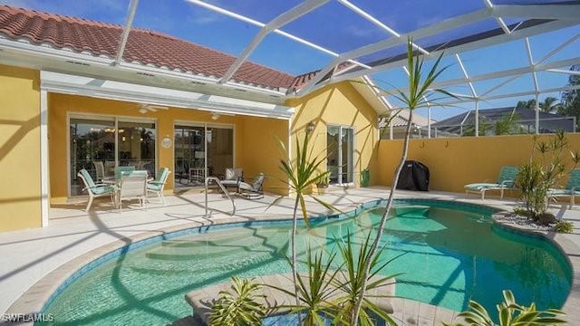 view of swimming pool with a lanai and a patio